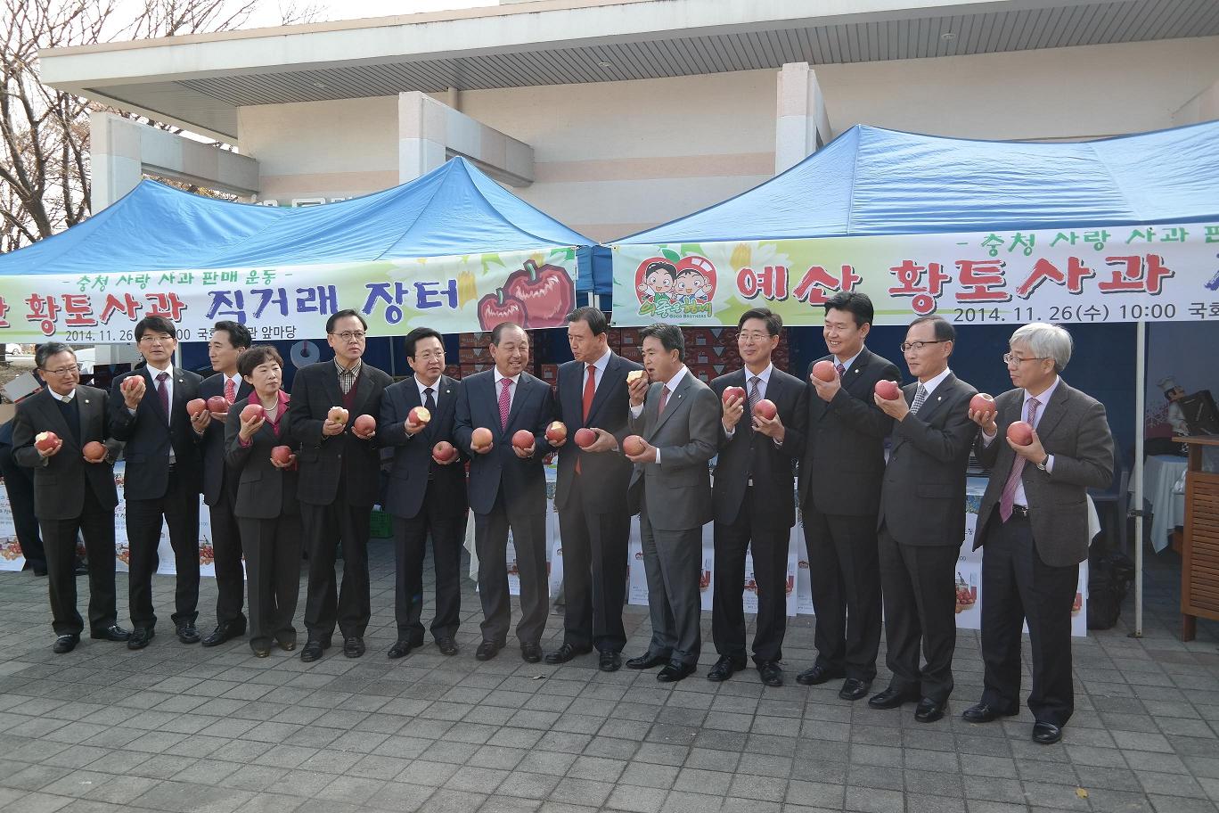 황선봉군수가 국회의사당 후생관 앞마당에서 열린 예산황토사과 직거래장터에서 충청권 국회의원들과 기념촬영 하고 있다.